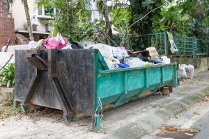 Rubbish dumspter or roro bin with load of waste from construction debris at residential area